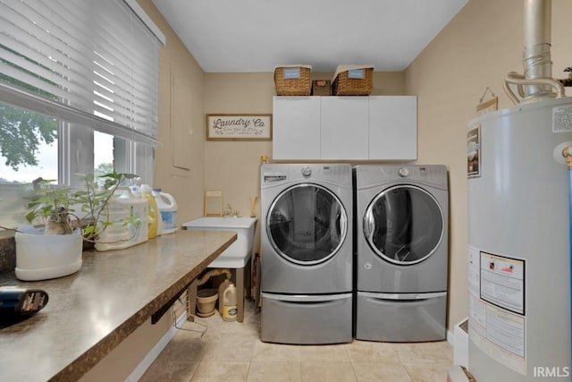 laundry room featuring light tile patterned floors, washing machine and dryer, water heater, and a sink