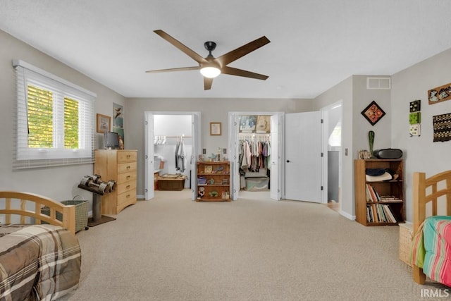 bedroom with a closet, visible vents, a ceiling fan, carpet flooring, and ensuite bath