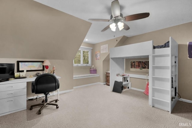 home office with lofted ceiling, a ceiling fan, light colored carpet, and baseboards