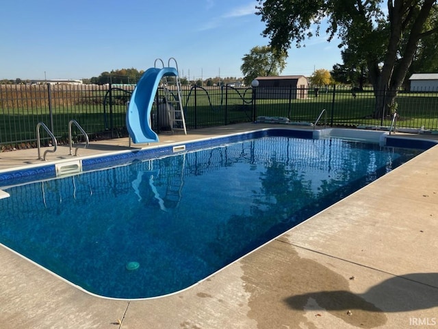 view of swimming pool featuring fence and a water slide