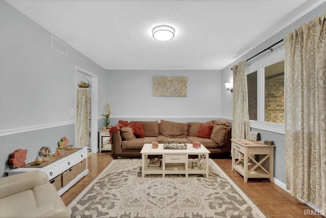 living room with visible vents and a textured ceiling