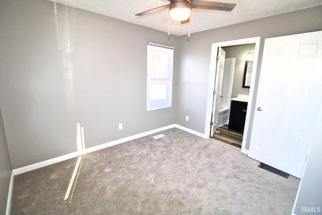 unfurnished bedroom with a ceiling fan, light carpet, ensuite bath, and baseboards