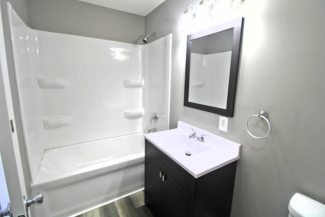 full bath with  shower combination, toilet, wood finished floors, and vanity