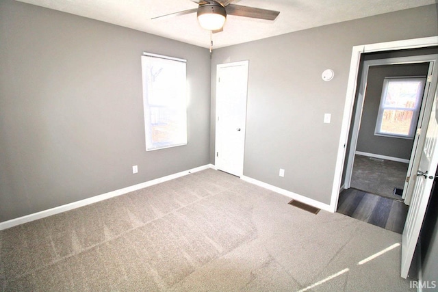 interior space featuring a closet, visible vents, a ceiling fan, carpet flooring, and baseboards