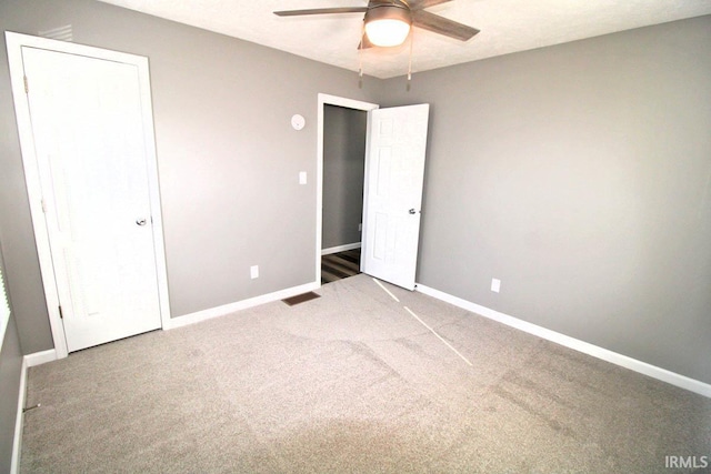 unfurnished bedroom featuring a ceiling fan, baseboards, and carpet flooring