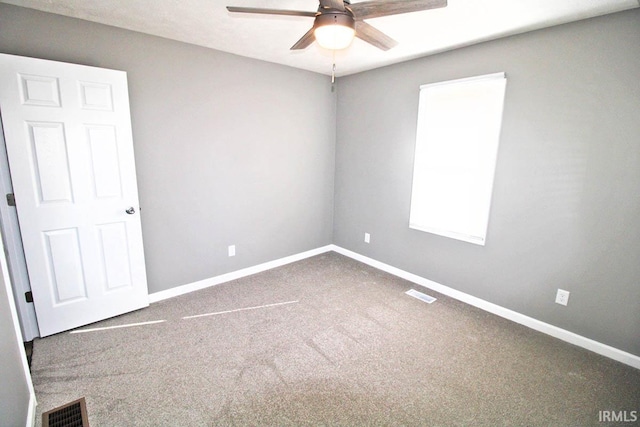 empty room featuring a ceiling fan, visible vents, carpet floors, and baseboards