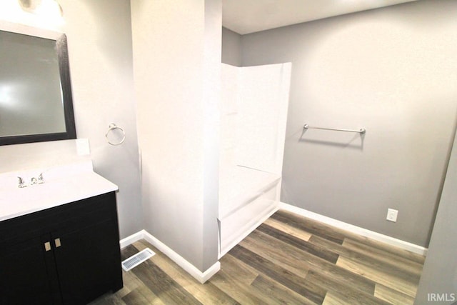 bathroom featuring baseboards, visible vents, wood finished floors, and vanity