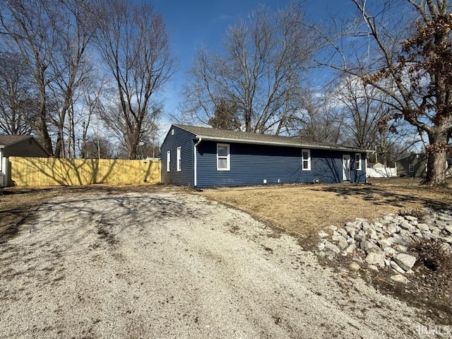 view of property exterior featuring driveway and fence