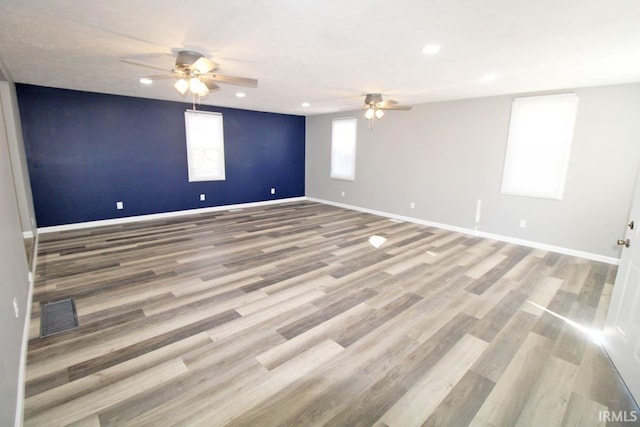 spare room featuring light wood finished floors, baseboards, visible vents, a ceiling fan, and recessed lighting