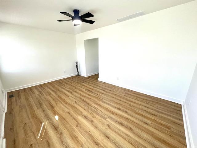 spare room with ceiling fan, light wood-style flooring, visible vents, and baseboards