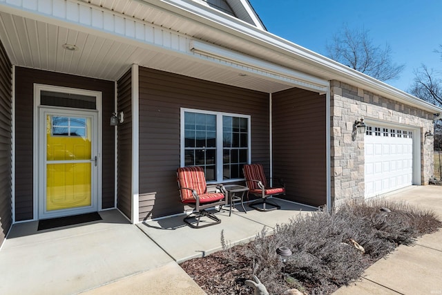 doorway to property with a garage and stone siding