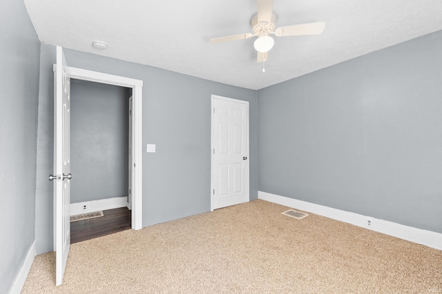 unfurnished bedroom with carpet floors, visible vents, and a ceiling fan