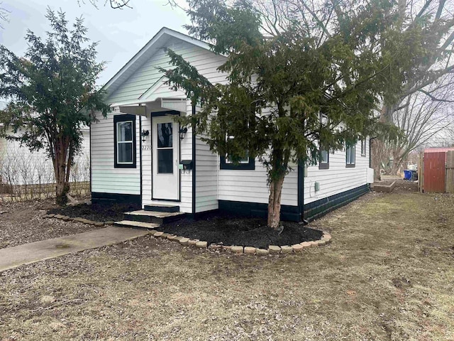 view of front of property featuring entry steps and a front lawn