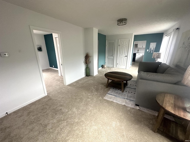 living area with baseboards and light colored carpet