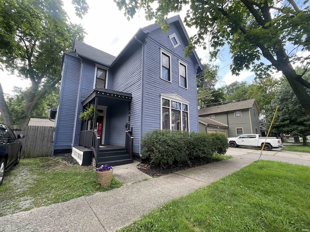 view of front facade featuring a front yard and fence