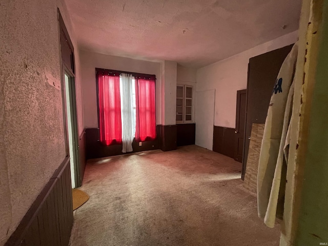 unfurnished room with a textured ceiling and carpet flooring