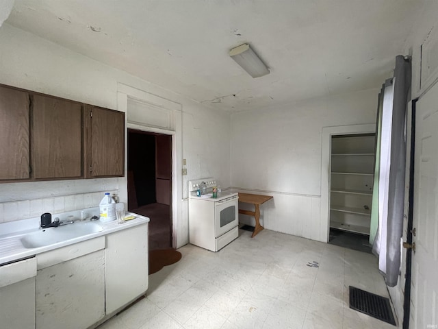 kitchen featuring light floors, light countertops, visible vents, a sink, and white appliances