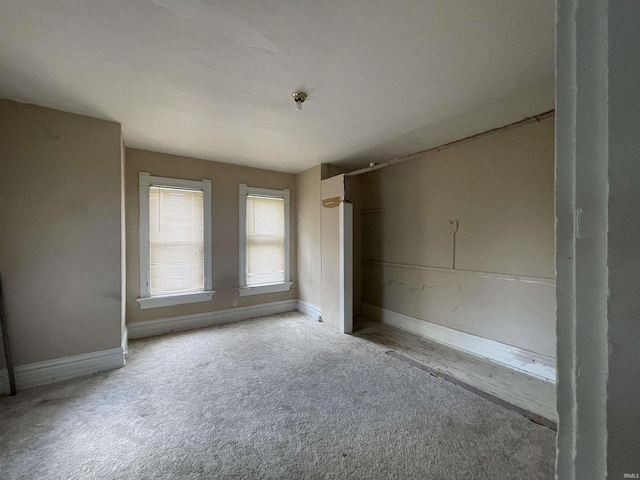 empty room featuring light carpet and baseboards