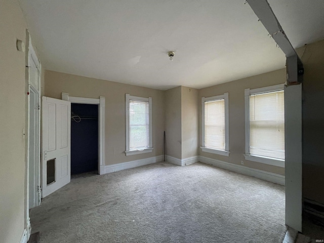 interior space featuring light carpet and baseboards