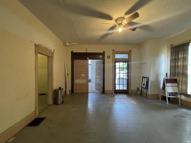 empty room featuring a textured ceiling, baseboards, and a ceiling fan