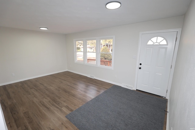 foyer entrance with dark wood-style floors, visible vents, and baseboards