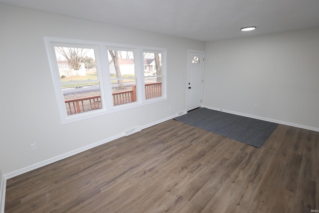 interior space with dark wood-style floors, baseboards, and visible vents