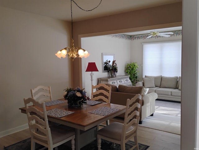 dining space featuring light wood-style flooring and baseboards