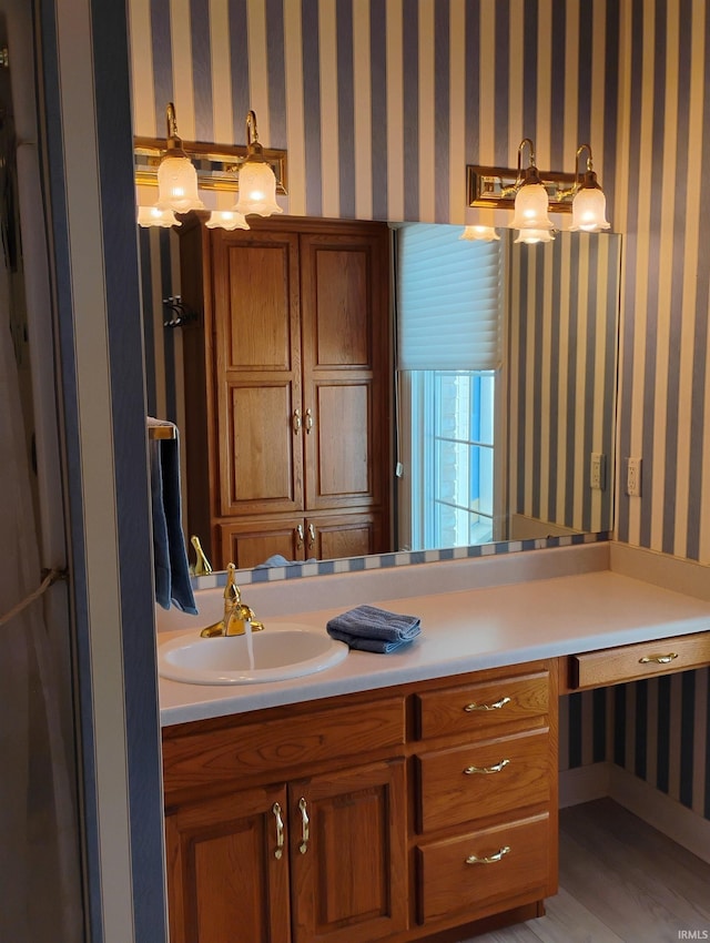 bathroom with vanity and wallpapered walls