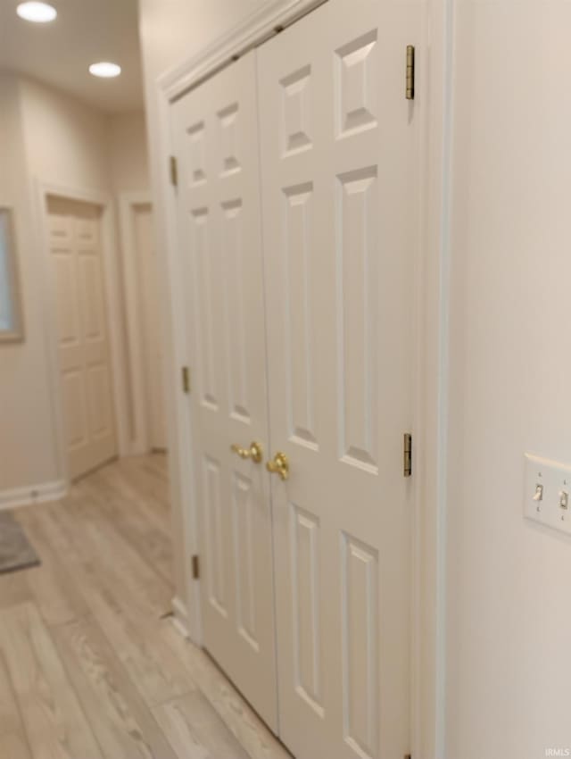 hallway with light wood-type flooring and recessed lighting