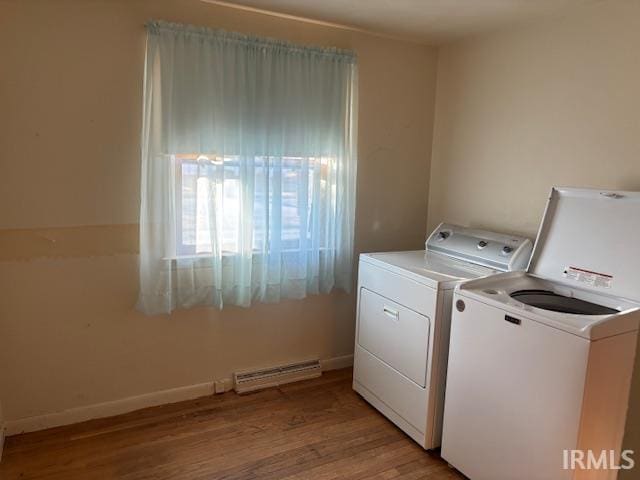 laundry room with light wood finished floors, a baseboard radiator, visible vents, laundry area, and independent washer and dryer