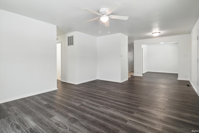 empty room featuring dark wood-style floors, visible vents, ceiling fan, and baseboards