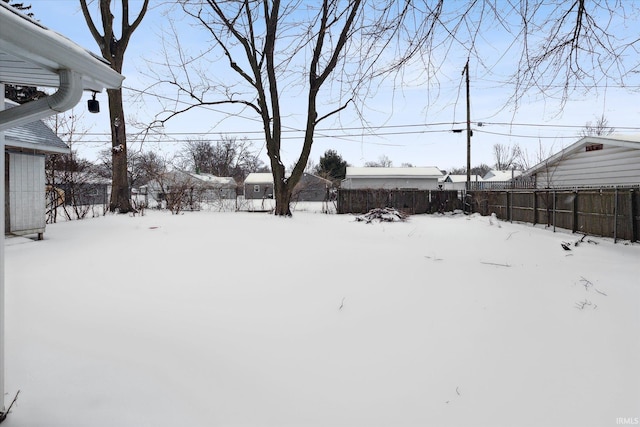 yard covered in snow featuring fence