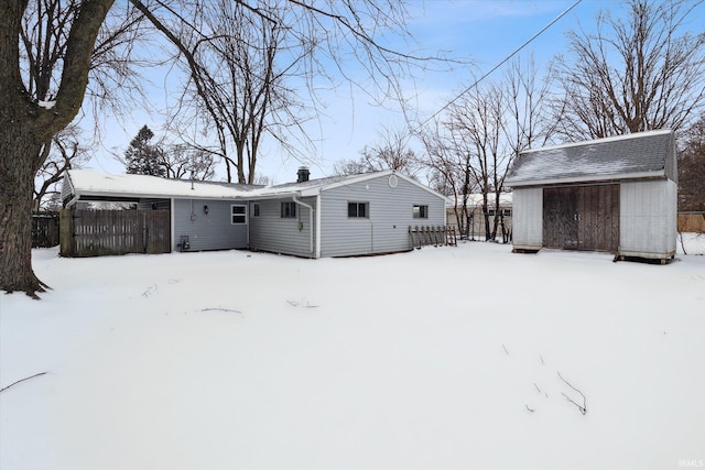 snow covered house with fence