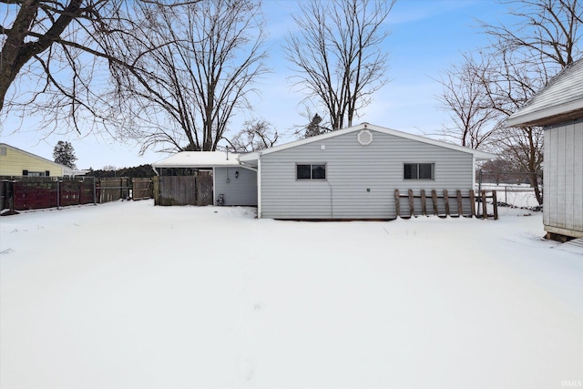 snow covered house featuring fence