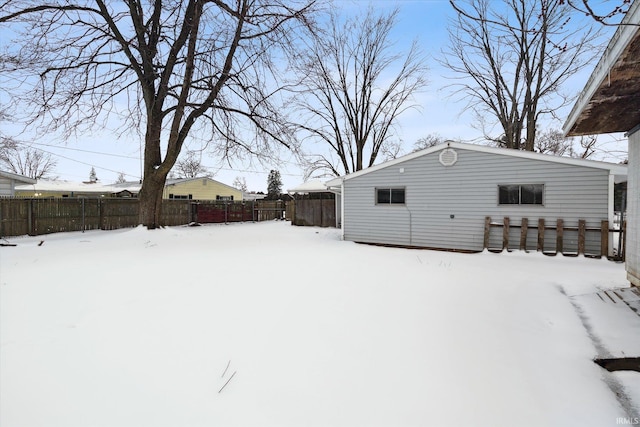 yard covered in snow with fence