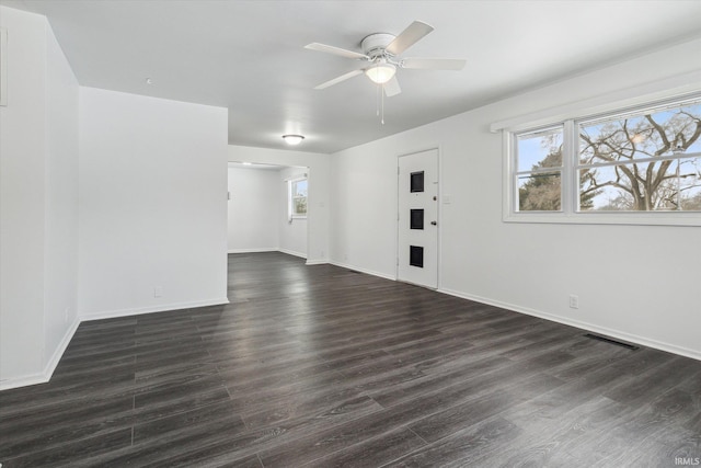 interior space featuring a ceiling fan, baseboards, visible vents, and dark wood-style flooring