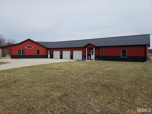 view of front of property with driveway, metal roof, a garage, and a front lawn