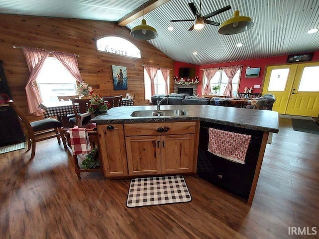 kitchen featuring wood walls, dark wood-style flooring, a sink, open floor plan, and dishwasher