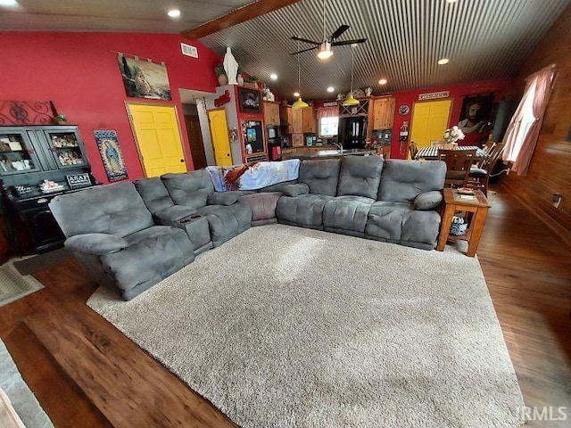 living room featuring lofted ceiling, visible vents, dark wood finished floors, and ceiling fan