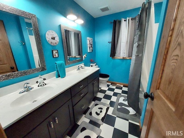 bathroom with toilet, visible vents, a sink, and tile patterned floors