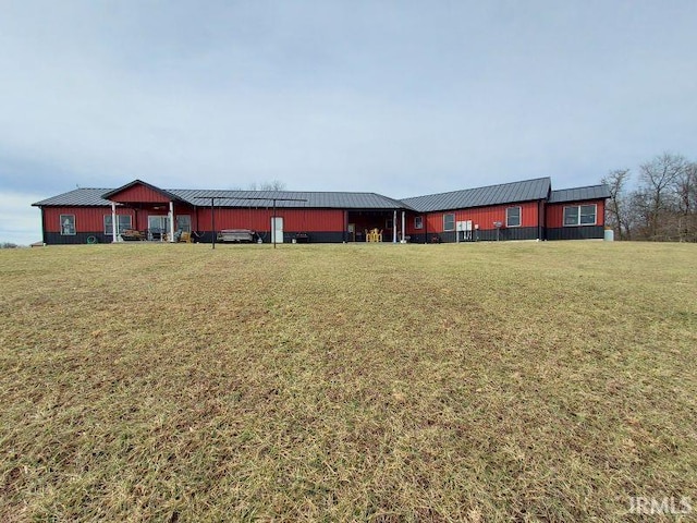 view of front of house with metal roof and a front lawn