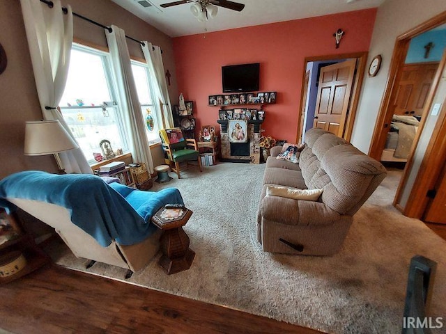 carpeted living area with a ceiling fan