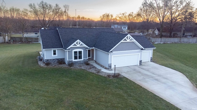 view of front of property featuring a garage, concrete driveway, a front yard, and fence