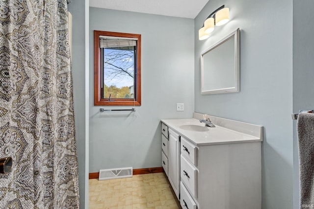 bathroom with visible vents, vanity, baseboards, and tile patterned floors