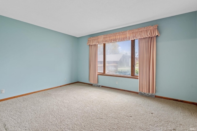 carpeted empty room featuring visible vents and baseboards