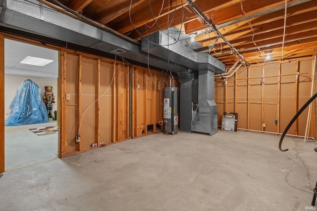 unfinished basement with gas water heater, visible vents, and heating unit