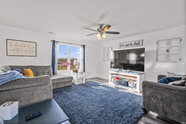 living area featuring a ceiling fan and wood finished floors