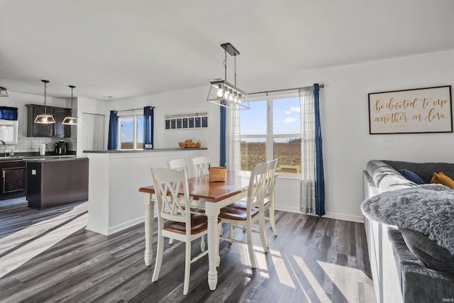 dining room with dark wood-style flooring, plenty of natural light, and baseboards