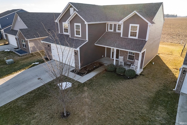 traditional home featuring driveway, a front lawn, a porch, and roof with shingles