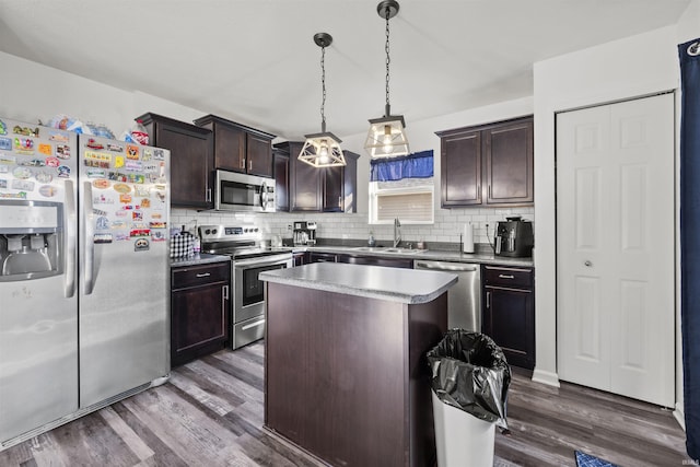 kitchen with a center island, decorative light fixtures, stainless steel appliances, a sink, and dark brown cabinets